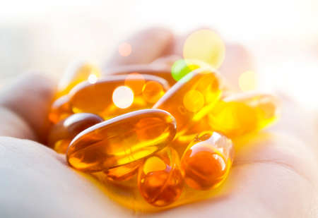 Cod liver oil pills in hand. Magic healing pills.