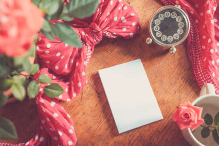 Blank card, roses and vintage clock on wooden background. Retro filter applied.の写真素材