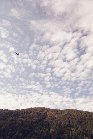 Mountains and village under the blue sky with a few clouds in Azuga, Romania. Retro filter applied.の写真素材
