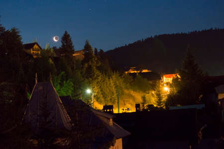 Mountain resort at night under sky full of stars and moon. Azuga, Romaniaの写真素材