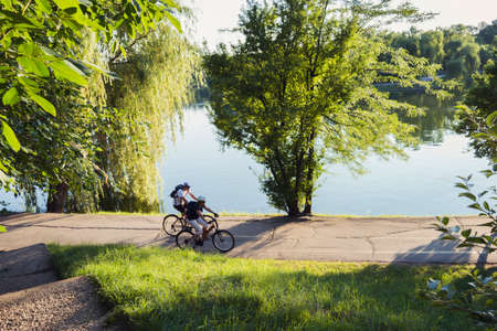 Bucharest, ROMANIA - June 22, 2015: People riding their bycicles at sunset in Tineretului park, Bucharest. BUCHAREST -June 22, 2015のeditorial素材