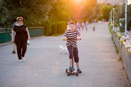 Bucharest, ROMANIA - June 22, 2015:  Young boy on a scooter in Tineretului park, Bucharest. BUCHAREST -June 22, 2015のeditorial素材
