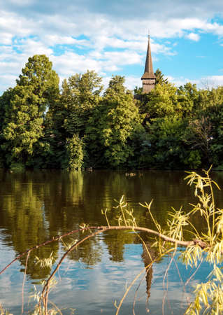 Church tower with cross reflected in the lake in Herastru park.の写真素材