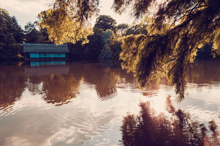 Peaceful lake view with old cabin on Herastrau lake in Bucharest, Romania. Retro filter applied.の写真素材