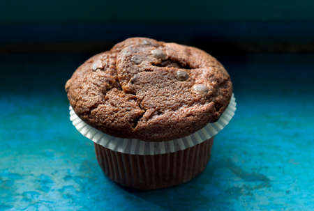Close-up of chocolate chip muffin on blue.