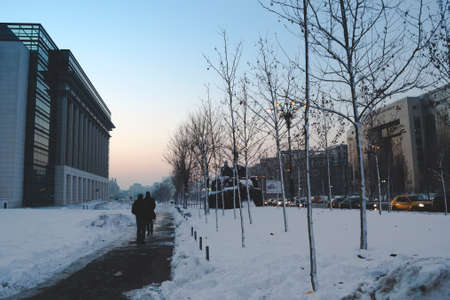 BUCHAREST, ROMANIA - January 22, 2016: People walking on Unirii Boulevard on a winter day between Bucharest Courthouse and the National Library building. BUCHAREST - January 22 2016のeditorial素材