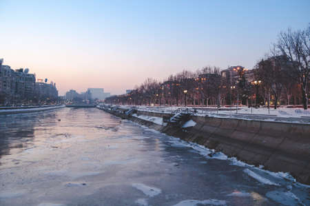 BUCHAREST, ROMANIA - January 22, 2016: View over Dambovita river and Unirii Boulevard towards the Parliament building at sunset on a winter day. BUCHAREST - January 22 2016のeditorial素材