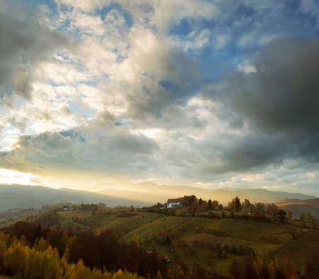 Wide view of hills and mountains bathed in warm sunset light in Transylvania, Poiana Marului.の写真素材