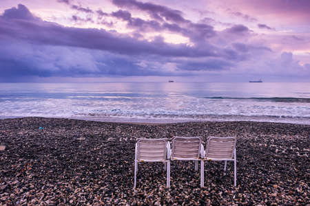 Empty chairs on the beach in Larnaca in warm sunrise light.の写真素材