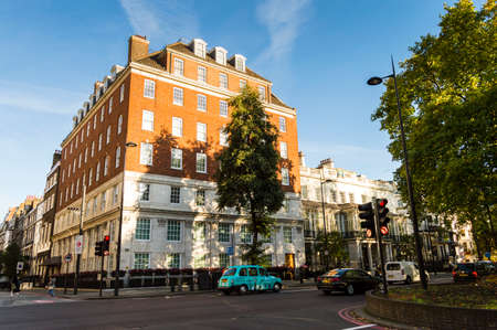 Sunny day on the streets of London near Hyde Park. Colorful cars and red brick wall buildingsのeditorial素材