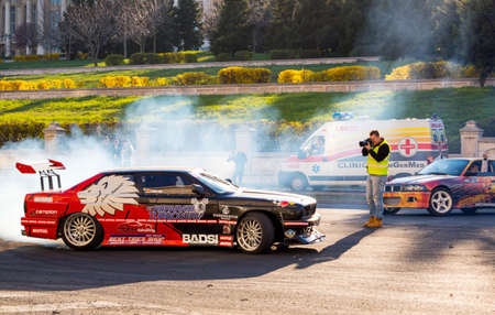 Drift car show at the Bucharest Auto Show. Sport car wheel drifting and people taking photographs