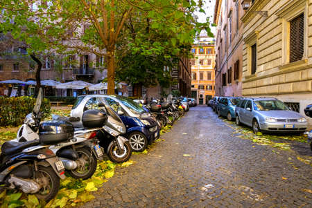 Rome ITALY - December 10 2018: Many colorful scooters and cars parked on a street in central Rome....