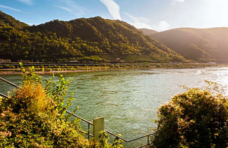 Autumn scenery on the Rhine river in Germany. Warm sunrise light on the sloped vineyards in...