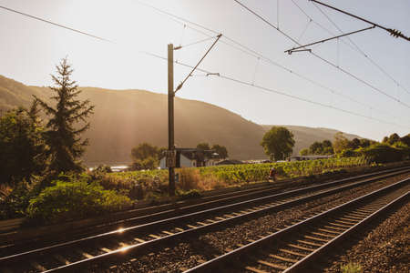 Trechtingshausen, Germany - September 18 2019: Woman riding a bike near the train tracks in Trechtingshausen on a sunny autumn morning, Rhine Valley, Germany.のeditorial素材