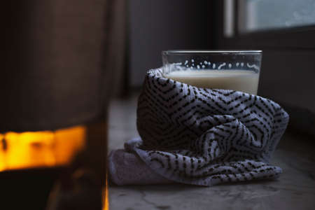 Hot cup of milk near the window on a rainy day. Self-care routineの写真素材