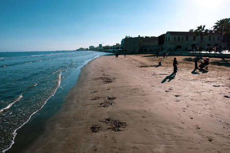 People strolling along Finikoudes beach in Larnaca on a sunny day in January.のeditorial素材