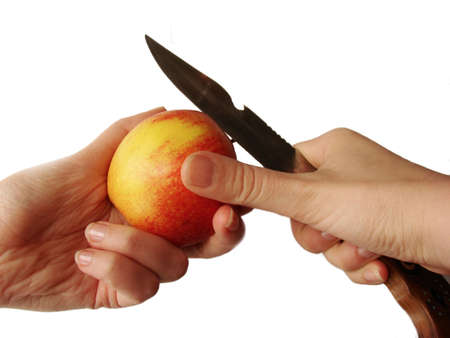 hands cutting apple with sharp hunter's knife isolated in whiteの写真素材