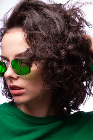 beautiful girl in green glasses and green sweaterの写真素材