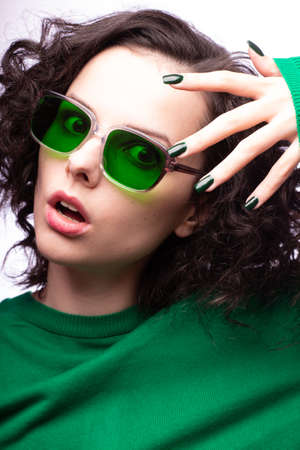 beautiful girl in green glasses and green sweaterの写真素材