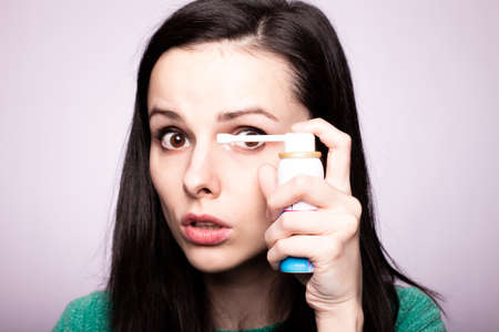 beautiful young girl holding cough medicineの写真素材