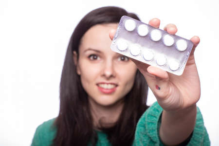 beautiful young girl holding pills in her handsの写真素材