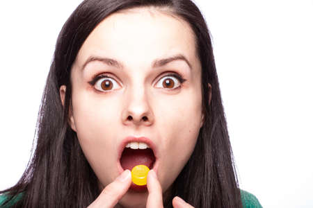 beautiful young girl holding in her mouth a lollipop against cough