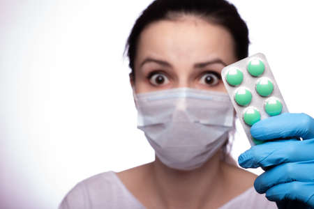 young woman in a medical poppy and gloves with a bag of pillsの写真素材