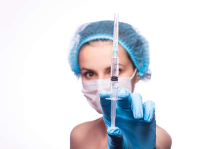 girl in medical mask wearing glasses and gloves is holding a syringeの写真素材