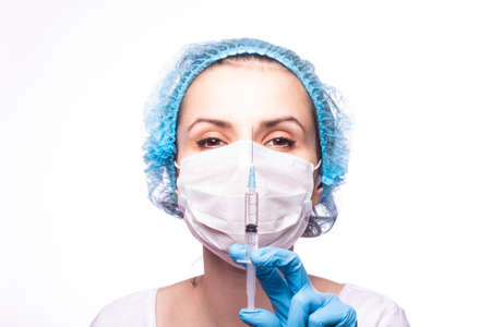 beautiful young girl in medical mask wearing glasses and gloves is holding a syringe