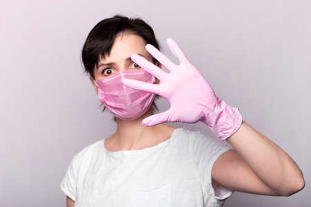 girl in a white t-shirt, pink mask and glovesの写真素材