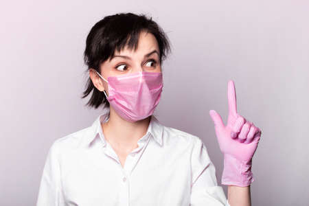 woman in a white t-shirt, pink mask and glovesの写真素材