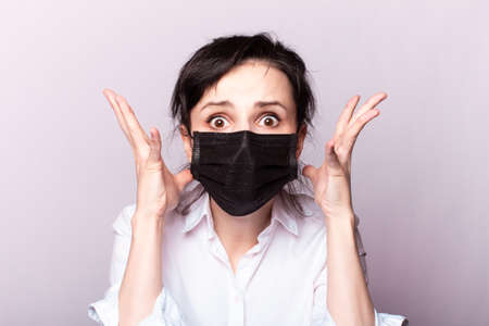 woman in a white shirt and black medical mask, panic