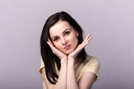 emotional girl in a t-shirt on a gray background