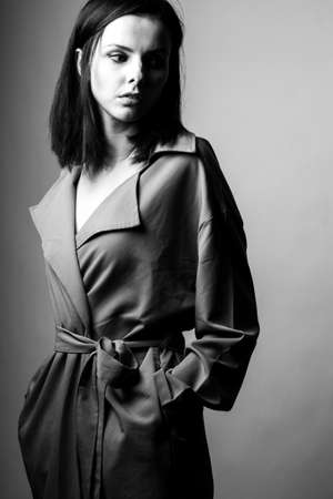 beautiful young woman in a trench coatの写真素材