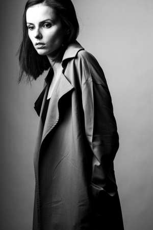 beautiful young girl in a trench coatの写真素材