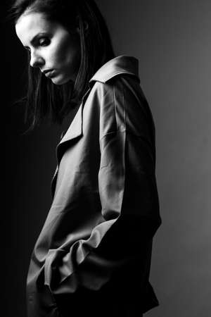 beautiful young woman in trench coat, brunette, black and white shotの写真素材