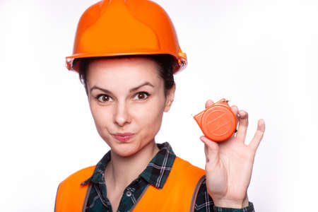 builder woman in uniform with tool in hand, light backgroundの写真素材