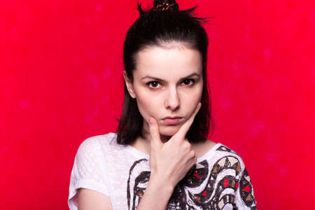 funny emotional woman in a t-shirt with a pattern on a red background