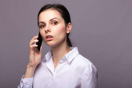 girl in a white shirt communicates on the phone