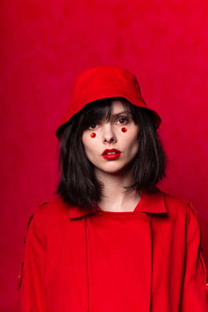 girl in red, rhinestones on her face, red backgroundの写真素材