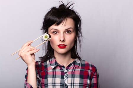 Woman eating sushi with chopsticks, rolls, asia, japan