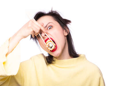 girl with red lipstick on her lips in a yellow sweater holds sticks sushi rolls Japan Asia