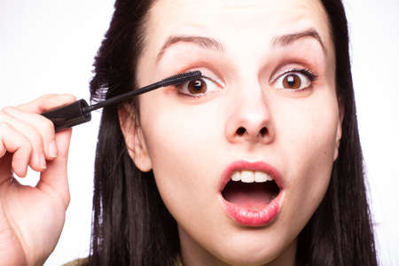 beautiful young girl paints eyelashesの写真素材