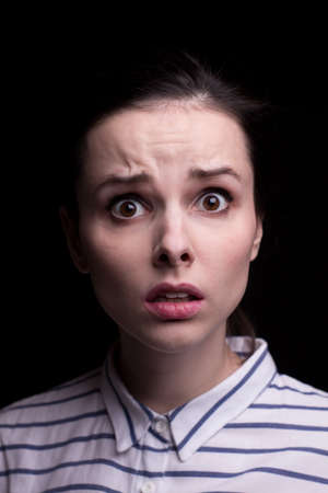 emotional woman in a striped shirt on a black background