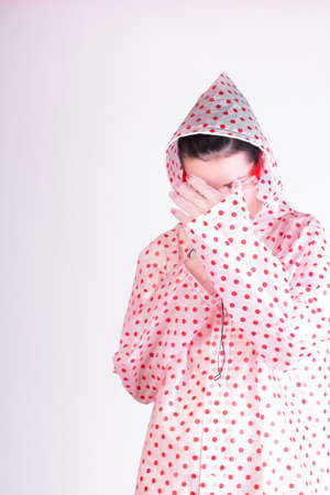 woman in a raincoat with red polka dots, transparent glassesの写真素材