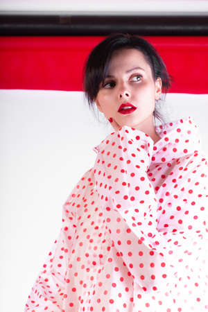 beautiful woman with red lips in a raincoatの写真素材