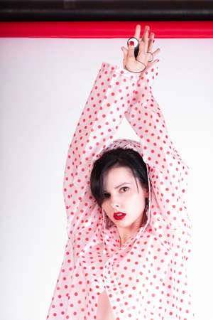 fashionable girl with red lips in a raincoatの写真素材