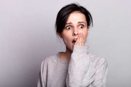 emotion woman in a gray t-shirt on a gray backgroundの写真素材