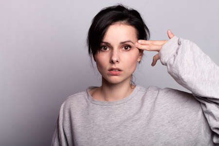 emotion woman in a gray t-shirt on a gray backgroundの写真素材
