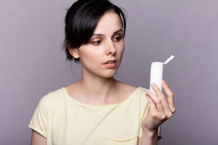 girl holds a jar of cosmetic solution in her hands